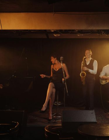pexels photo 9419224 9419224 A jazz band performing with a female singer and musicians playing piano, saxophone, and guitar on stage.
